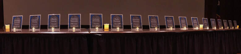 Fifteen memorial plaques displayed with candles for the victims of the Porvenir Massacre